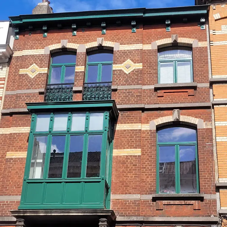 Travaux en hauteur Bruxelles finis peinture verte corniche loggia châssis beau résultat sur maison de maître en brique de Schaerbeek